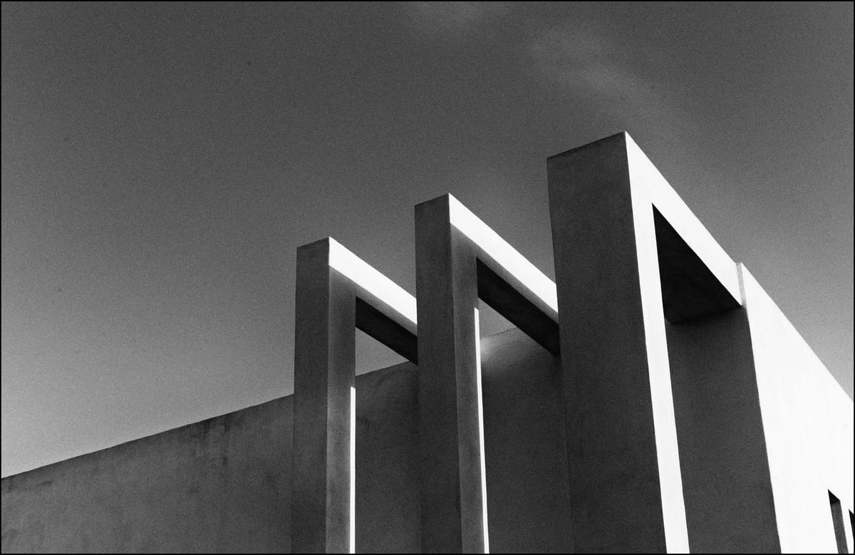 Tre colonne di una casa in stile contemporaneo creano un gioco di luci. Fotografia in bianco e nero
